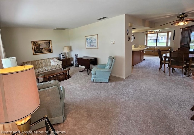 carpeted living room with ceiling fan