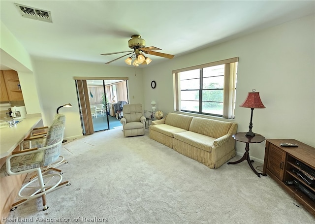 carpeted living room featuring ceiling fan