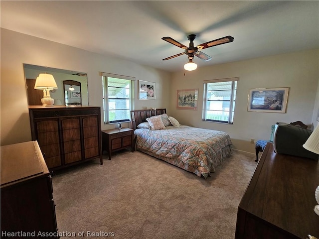 carpeted bedroom with ceiling fan and multiple windows