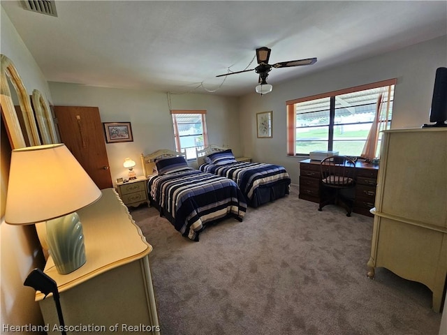 bedroom with multiple windows, ceiling fan, and carpet floors