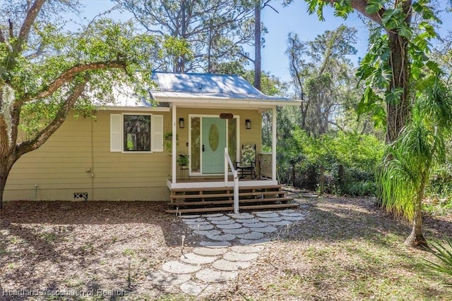 view of front of home featuring crawl space, metal roof, and a porch