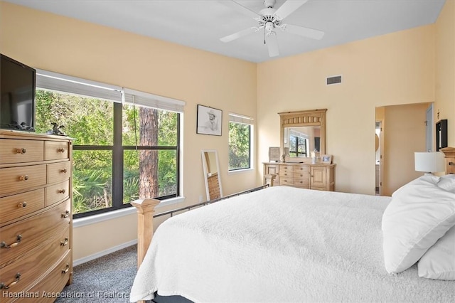 carpeted bedroom featuring lofted ceiling, visible vents, ceiling fan, and baseboards