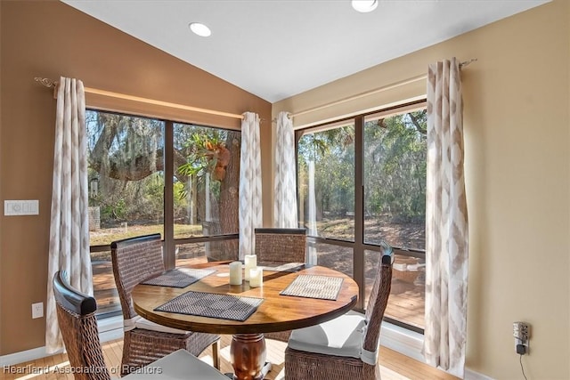 dining room with recessed lighting, vaulted ceiling, baseboards, and wood finished floors