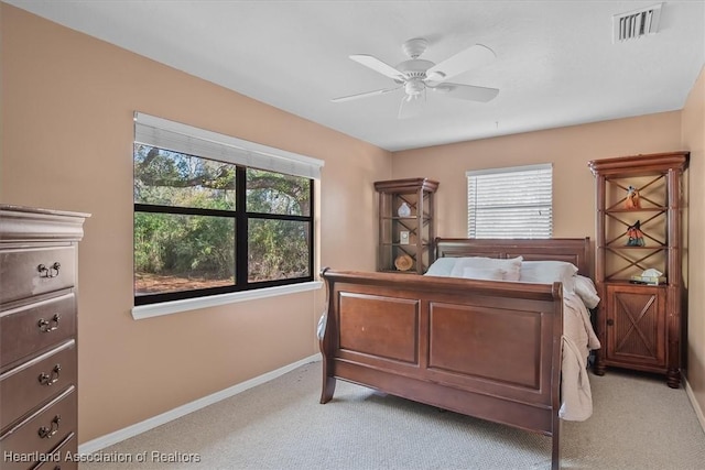 bedroom featuring light colored carpet, visible vents, ceiling fan, and baseboards