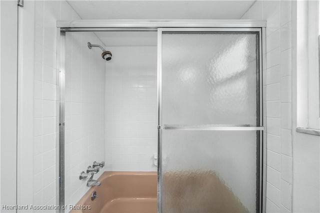 bathroom with combined bath / shower with glass door