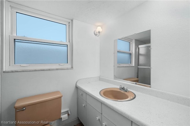 bathroom with walk in shower, vanity, a textured ceiling, and toilet