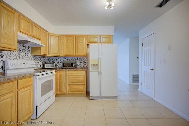 kitchen featuring white appliances, under cabinet range hood, visible vents, and tasteful backsplash