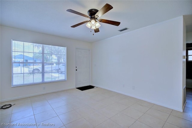 unfurnished room with light tile patterned floors, baseboards, a ceiling fan, and visible vents