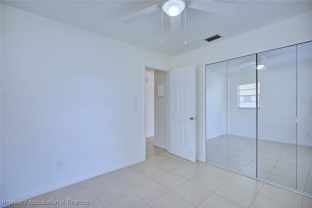 unfurnished bedroom featuring light tile patterned floors, baseboards, and a closet