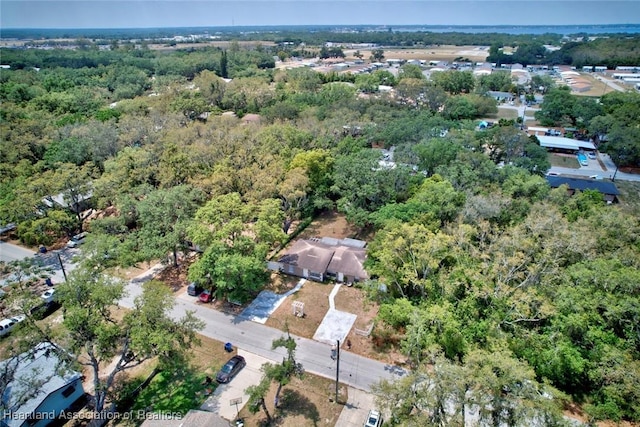 drone / aerial view featuring a wooded view