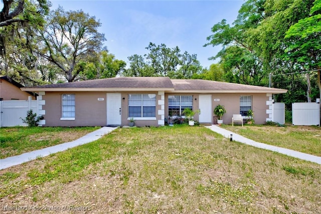 single story home featuring fence, stucco siding, and a front lawn