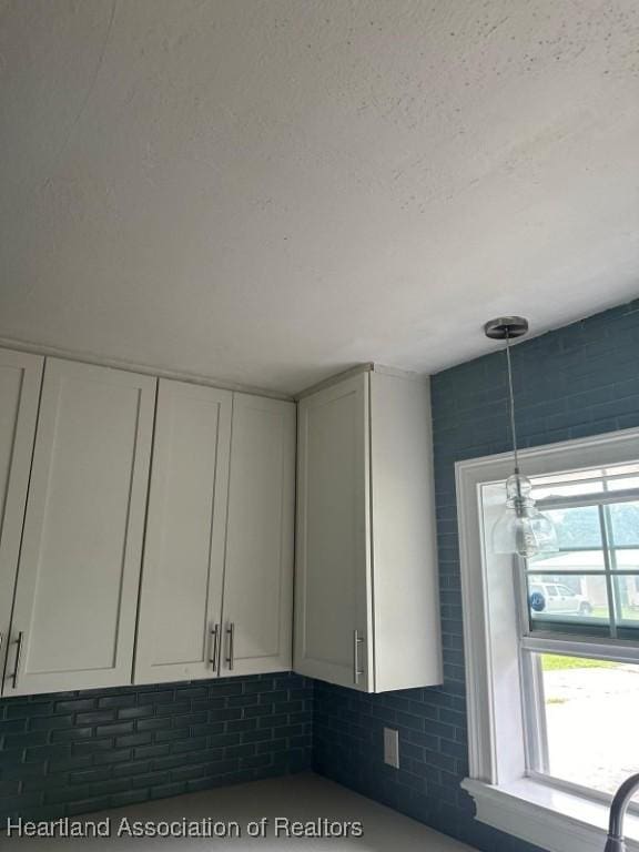 interior space with decorative backsplash and white cabinetry