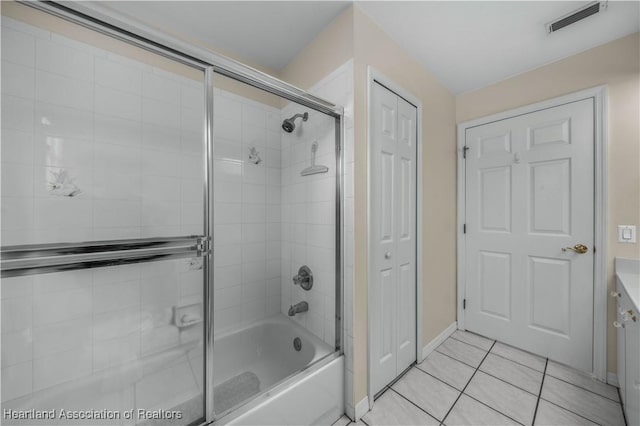 bathroom with enclosed tub / shower combo, tile patterned floors, and vanity