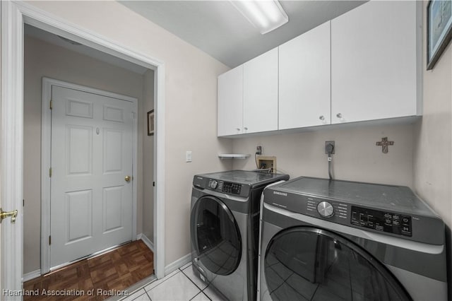 washroom with washer and clothes dryer and cabinets