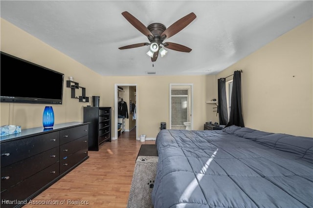 bedroom featuring a spacious closet, hardwood / wood-style floors, connected bathroom, a closet, and ceiling fan