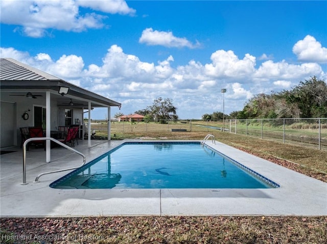 view of swimming pool with ceiling fan and a patio area