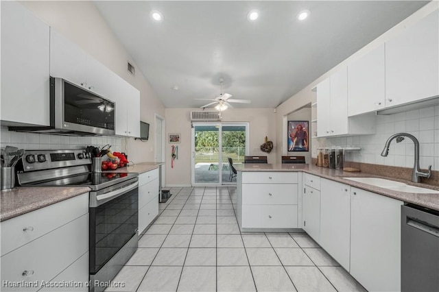 kitchen with ceiling fan, kitchen peninsula, sink, appliances with stainless steel finishes, and white cabinets