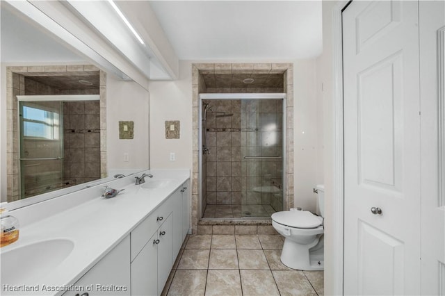 bathroom with vanity, tile patterned floors, and a shower with door