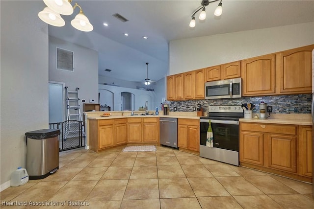 4703 Benton St, Lake Wales, FL 33859 - kitchen with appliances with stainless steel finishes, tasteful backsplash, light tile patterned flooring, high vaulted ceiling, and light countertops