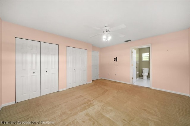 5808 Twisted Oaks Dr, Sebring, FL 33876 - unfurnished bedroom featuring multiple closets, baseboards, light colored carpet, and connected bathroom