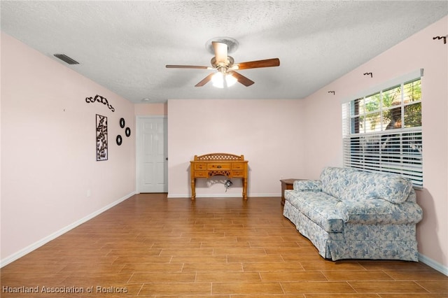 5808 Twisted Oaks Dr, Sebring, FL 33876 - sitting room with ceiling fan, light wood finished floors, a textured ceiling, and baseboards