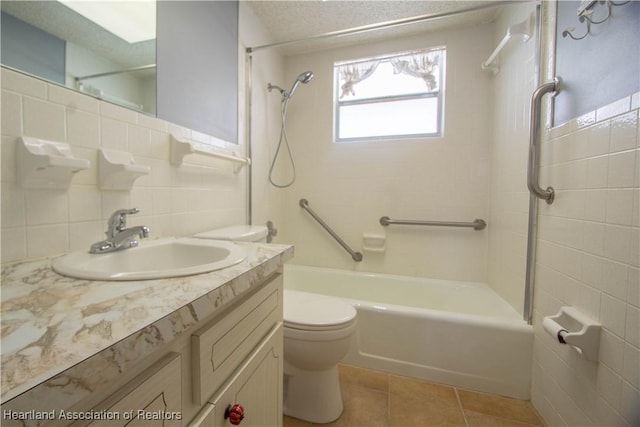 full bathroom featuring toilet, tiled shower / bath, vanity, tile patterned floors, and decorative backsplash