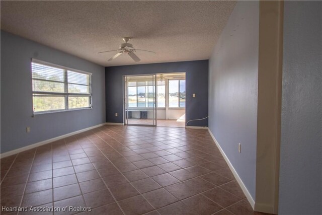 sunroom featuring ceiling fan and a water view