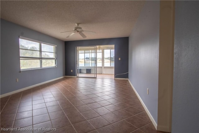 living room with ceiling fan, light tile patterned floors, and a textured ceiling