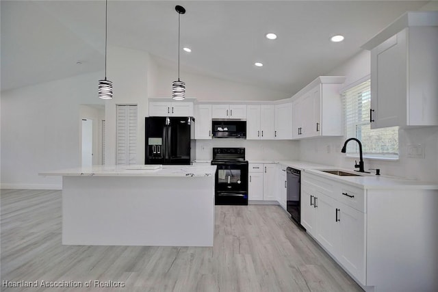 kitchen featuring pendant lighting, white cabinetry, a kitchen island, and black appliances