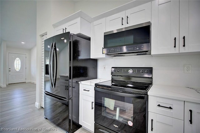 kitchen with white cabinetry and black appliances