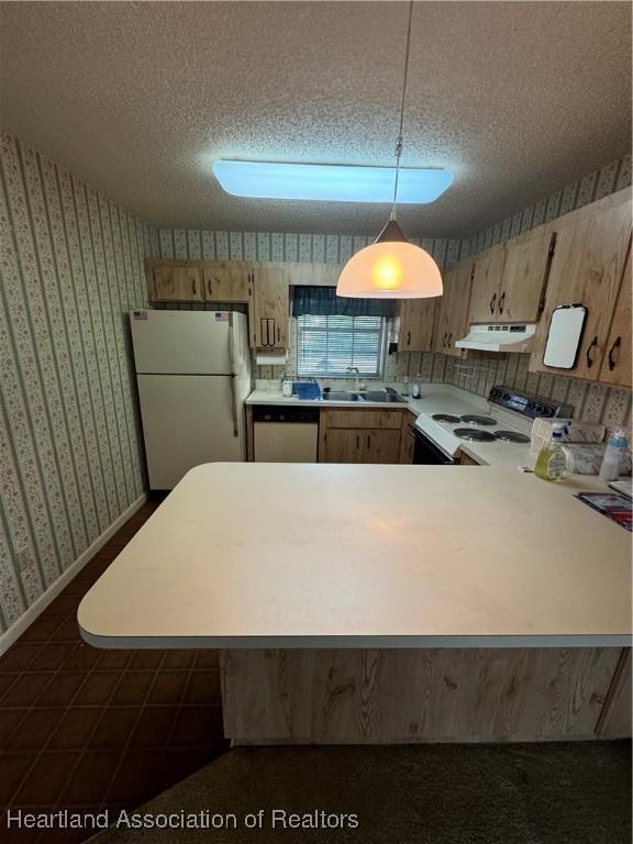 kitchen with hanging light fixtures, sink, a textured ceiling, and white appliances