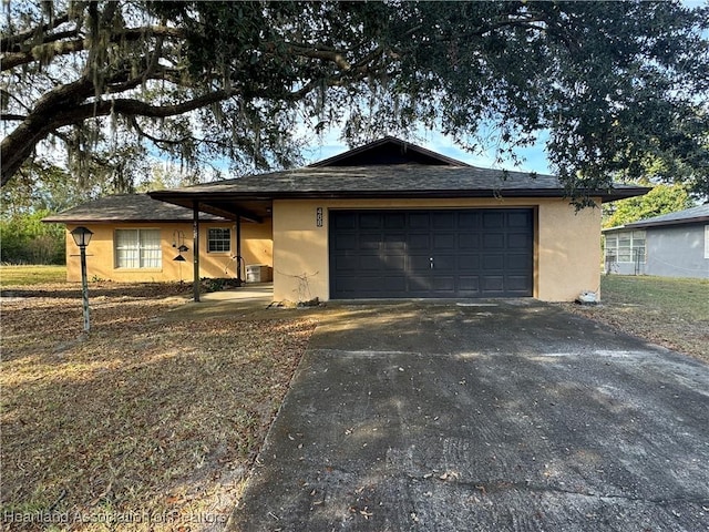 single story home featuring cooling unit and a garage