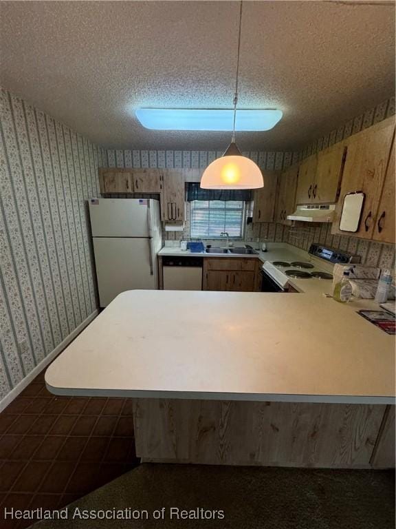 kitchen with kitchen peninsula, a textured ceiling, white appliances, and decorative light fixtures