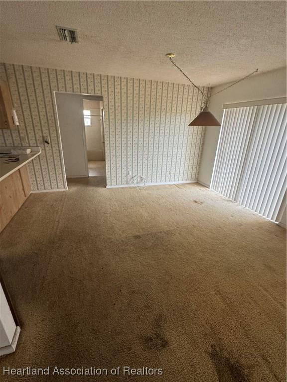 carpeted empty room featuring a textured ceiling