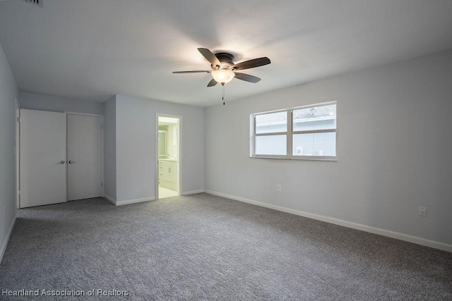 unfurnished bedroom with ceiling fan, a closet, connected bathroom, and carpet floors