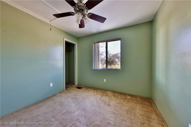 unfurnished bedroom with light carpet, a closet, and ceiling fan