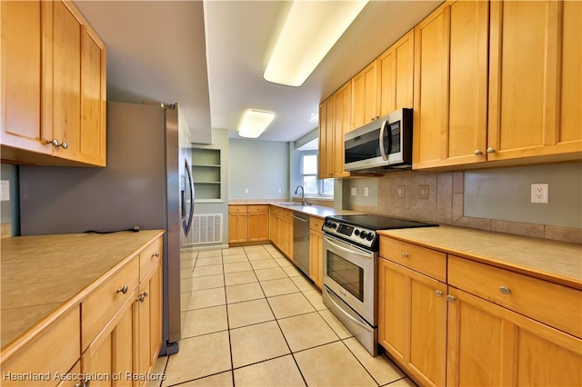 kitchen featuring light tile patterned flooring, appliances with stainless steel finishes, and sink