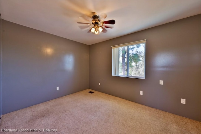 empty room with ceiling fan and carpet