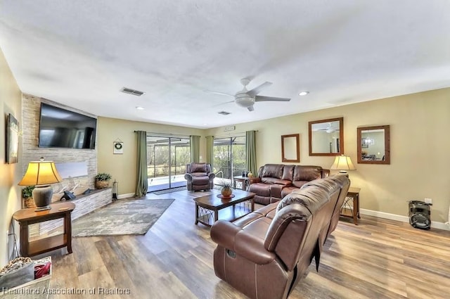 living room featuring light hardwood / wood-style floors and ceiling fan