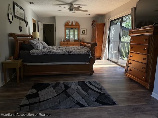 bedroom with a textured ceiling, dark hardwood / wood-style flooring, access to outside, and ceiling fan