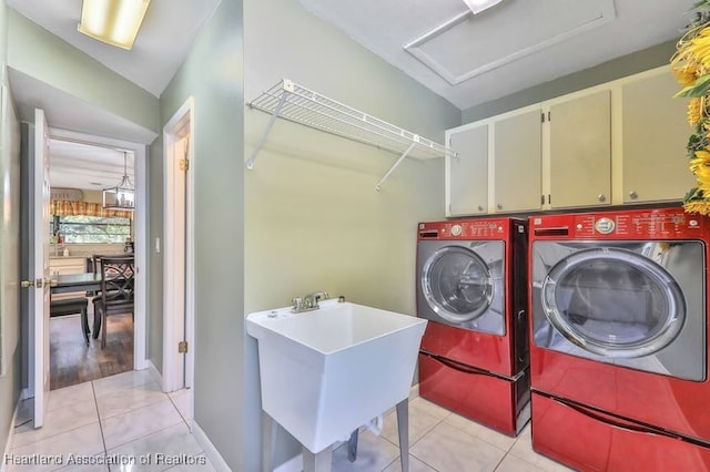 washroom with sink, light tile patterned flooring, cabinets, and independent washer and dryer