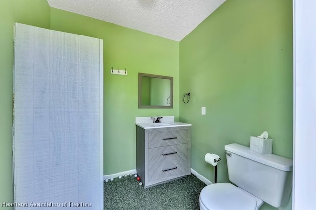 bathroom with vanity, a textured ceiling, and toilet