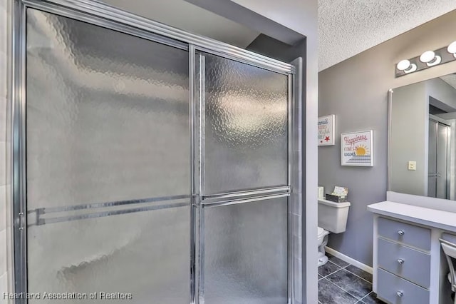 bathroom featuring a shower with door, vanity, a textured ceiling, and tile patterned flooring