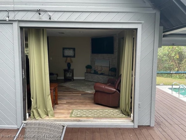 view of exterior entry featuring a fireplace and a wooden deck