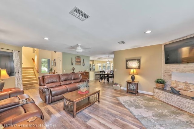 living room with light hardwood / wood-style floors and ceiling fan