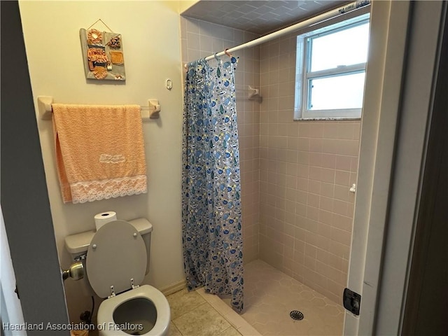 bathroom featuring toilet, tile patterned floors, and curtained shower