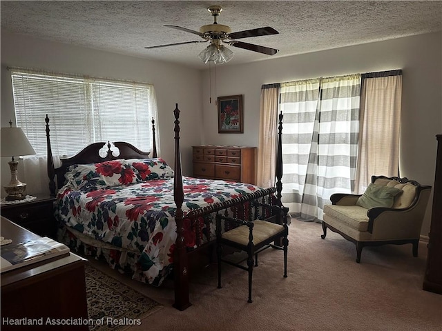 bedroom featuring a textured ceiling, ceiling fan, and carpet flooring