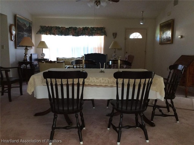 carpeted dining space featuring ceiling fan