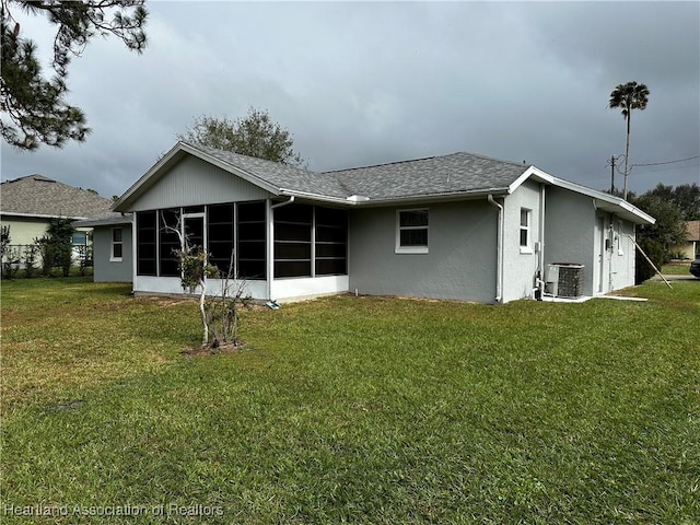 back of house featuring cooling unit, a sunroom, and a lawn