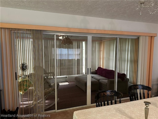 bedroom featuring a textured ceiling, a chandelier, and carpet flooring